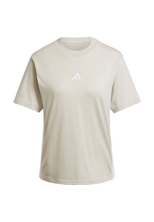T-shirt en coton beige clair avec un col rond et des manches courtes. Présente un petit logo Adidas blanc sur la poitrine. Texture douce et coupe décontractée.