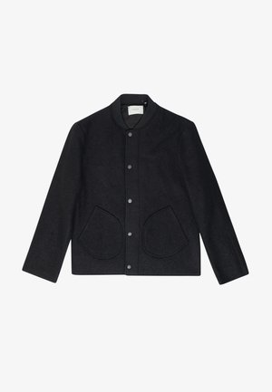 Giacca nera in lana con colletto tondo, bottoni a pressione, due grandi tasche arrotondate e superficie testurizzata. Design semplice con maniche lunghe.