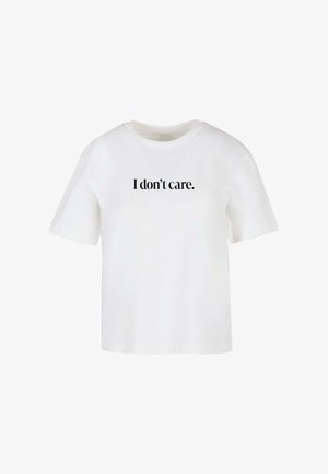 Fehér pamut póló rövid ujjakkal, középen fekete nyomtatott szöveggel: "Nem érdekel." Puha tapintású, laza fazonú.