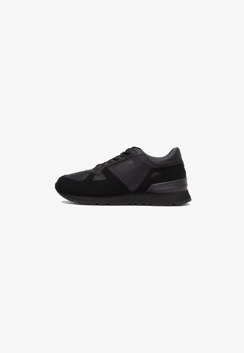 Schwarze Sport Schuhe mit einem strukturierten Obermaterial aus Mesh- und Wildleder, Schnürdesign und einer kontrastierenden Gummisohle.