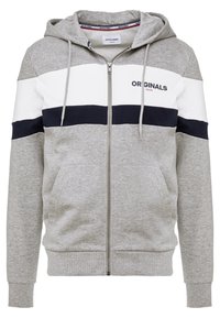 Sudadera gris con cremallera, con una franja blanca en el pecho y detalles en azul marino. Cuenta con capucha ajustable con cordones y bolsillos tipo canguro. Hecha de una suave mezcla de algodón.