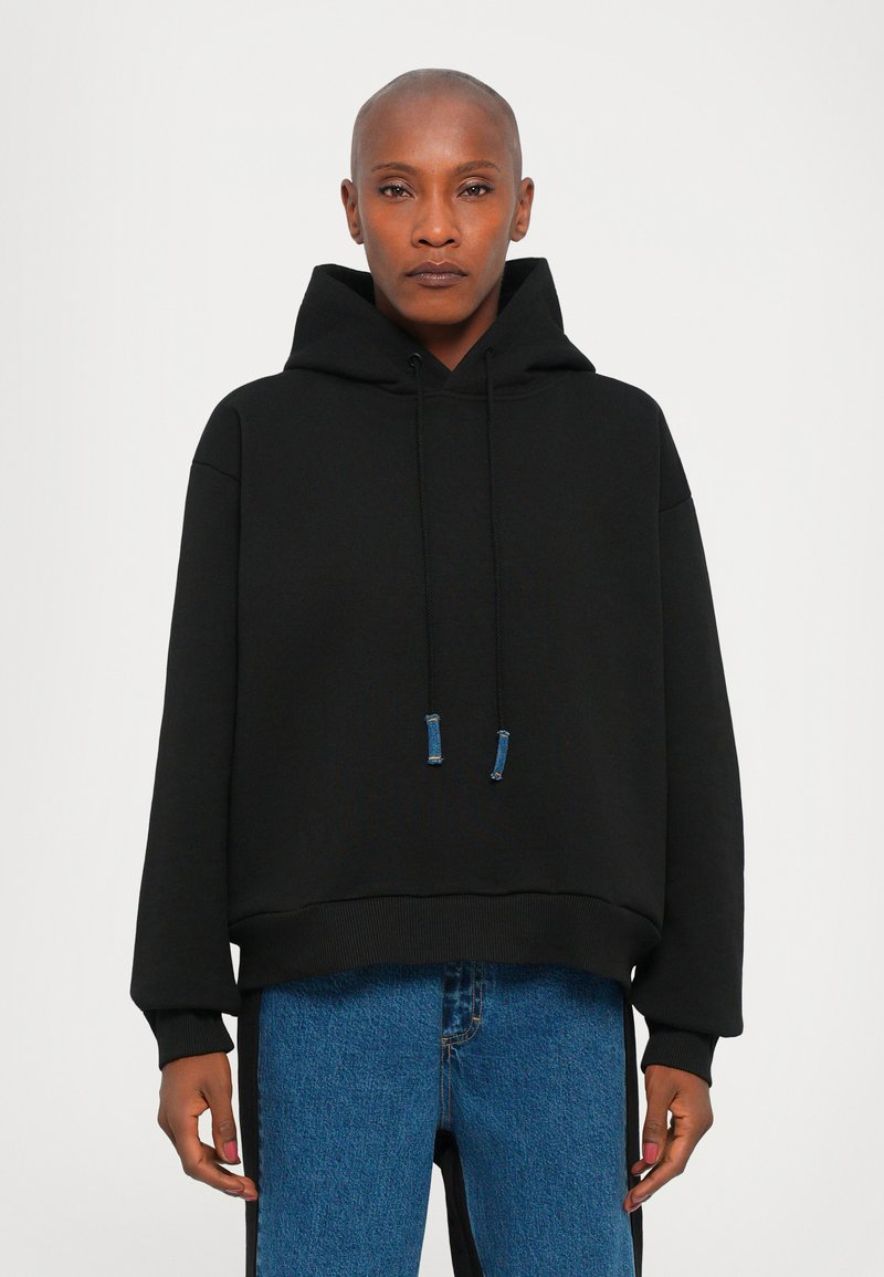 Schwarzer Kapuzenpullover aus weichem Material, mit lockerer Passform, geripptem Saum und kontrastierenden blauen Kordelzügen.
