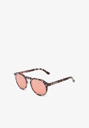 Kerek napszemüveg, mintás sötét teknősborítású kerettel, rózsaszín lencsékkel és fém logó részlettel a szárakon.
