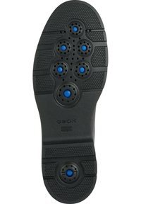 Suela de zapato de goma negra con acentos circulares azules, orificios de ventilación, áreas de agarre texturizadas y marcas de "GEOX" y "PATENTE ITALIANA".