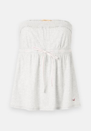 Gray strapless top with elastic neckline, gathered bodice, and adjustable tie with red stitching at the waist. Small logo on the hem.