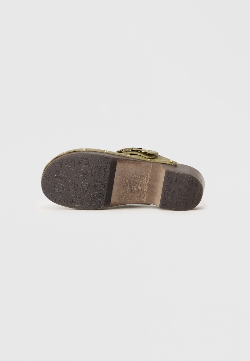 Schuhe mit einer braunen Gummisohle, die ein strukturiertes Muster aufweist, einem olivgrünen Obermaterial, einem Metallverschluss und einer glatten Oberfläche.