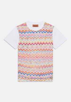 Pamut póló fehér testtel, élénk színű cikkcakk mintával, melyben rózsaszín, kék, sárga és fémes árnyalatok is megjelennek. Kerek nyakkivágás.
