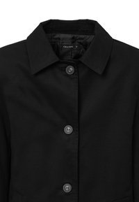 Giacca nera con bottoni, caratterizzata da un colletto classico, bottoni metallici e una texture liscia, progettata per una vestibilità su misura. Etichetta del brand visibile.