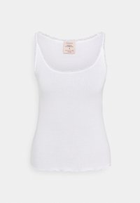 Vit ribbad tanktopp med en vågig spetskant längs halsringningen och ärmhålen. Har en liten märkesetikett på baksidan.