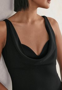 Černý top bez rukávů s volným výstřihem, vyrobený z hladké tkaniny a se skvěle padnoucím střihem. Žádné viditelné zapínání ani odlišné vzory.