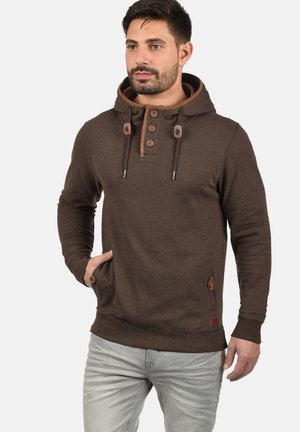 Bruine hoodie met een knoopsluiting, aantrekkoorden, zijzakken en contrasterende accenten. Gemaakt van zachte stof, met een relaxte pasvorm.