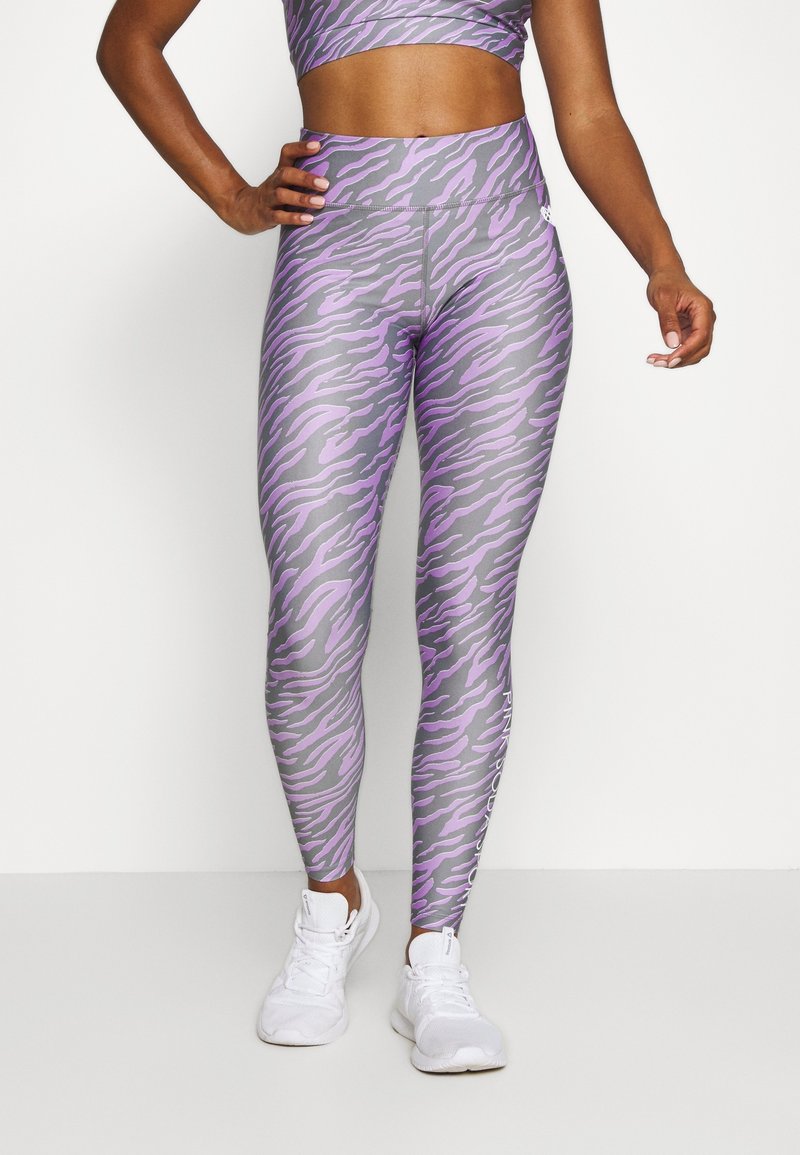High-waisted leggings in gray with a purple tiger stripe pattern. Made of stretchy material, featuring a logo on the left leg and a smooth texture.