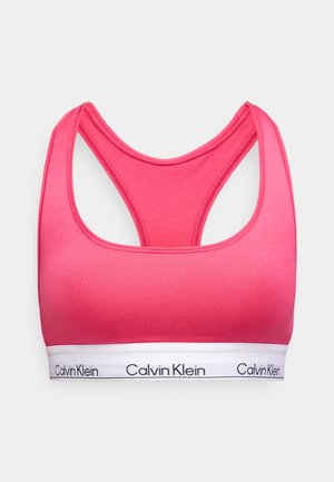 Sutien sport roz cu un design tip racerback, realizat dintr-un material neted. Dispune de o bandă albă cu „Calvin Klein” imprimată în negru.
