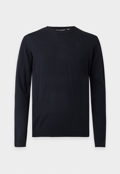 Pull noir à manches longues avec col rond, poignets et ourlet côtelés, présenté sur un fond gris clair uni.