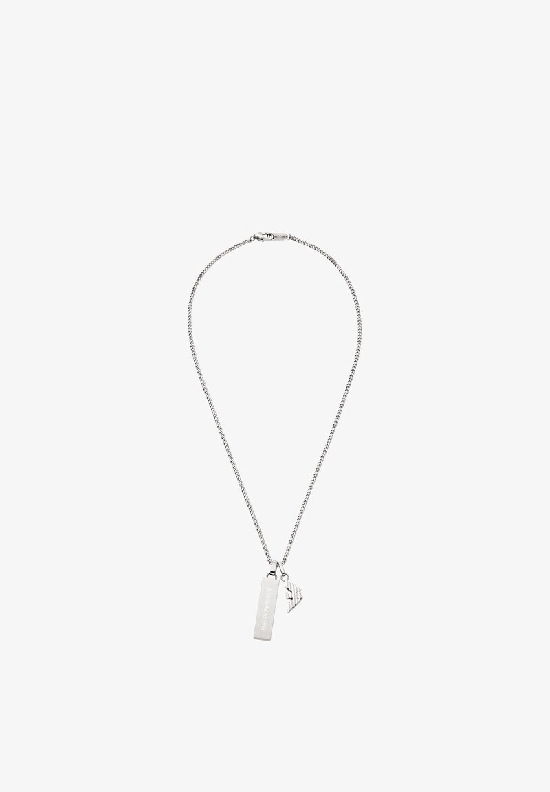 Collier en chaîne argentée avec deux pendentifs : une étiquette rectangulaire et une forme géométrique avec des détails gravés. Texture lisse et design minimaliste.
