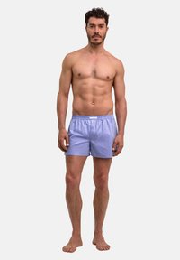 Boxers pour hommes à carreaux bleus en coton doux, dotés d'une taille élastique et d'une coupe décontractée. Sans poches ni détails métalliques visibles.