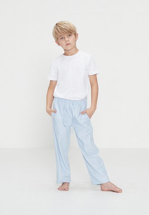 Hvid kortærmet t-shirt parret med lyseblå, lodret stribede, afslappede pyjamasbukser med elastisk talje og sidelommer.