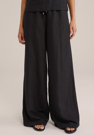 Black wide-leg pants made of a lightweight, textured fabric. Features a drawstring waist with decorative beads. Smooth hemline.
