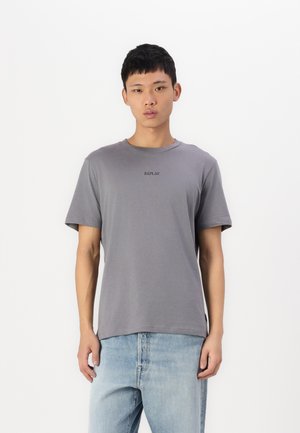 Grå bomulds T-shirt med rund hals, korte ærmer og et lille "REPLAY" logo trykt på brystet, parret med lyseblå jeans.
