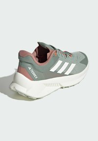 Sneaker Adidas Terrex verdi e rosa con strisce bianche, tomaia in rete, colletto imbottito e suola bianca testurizzata per trazione.