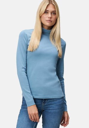 Lichtblauw langemouwen coltrui gemaakt van zacht stof, met een aansluitend ontwerp en geribbelde manchetten, gecombineerd met blauwe jeans.