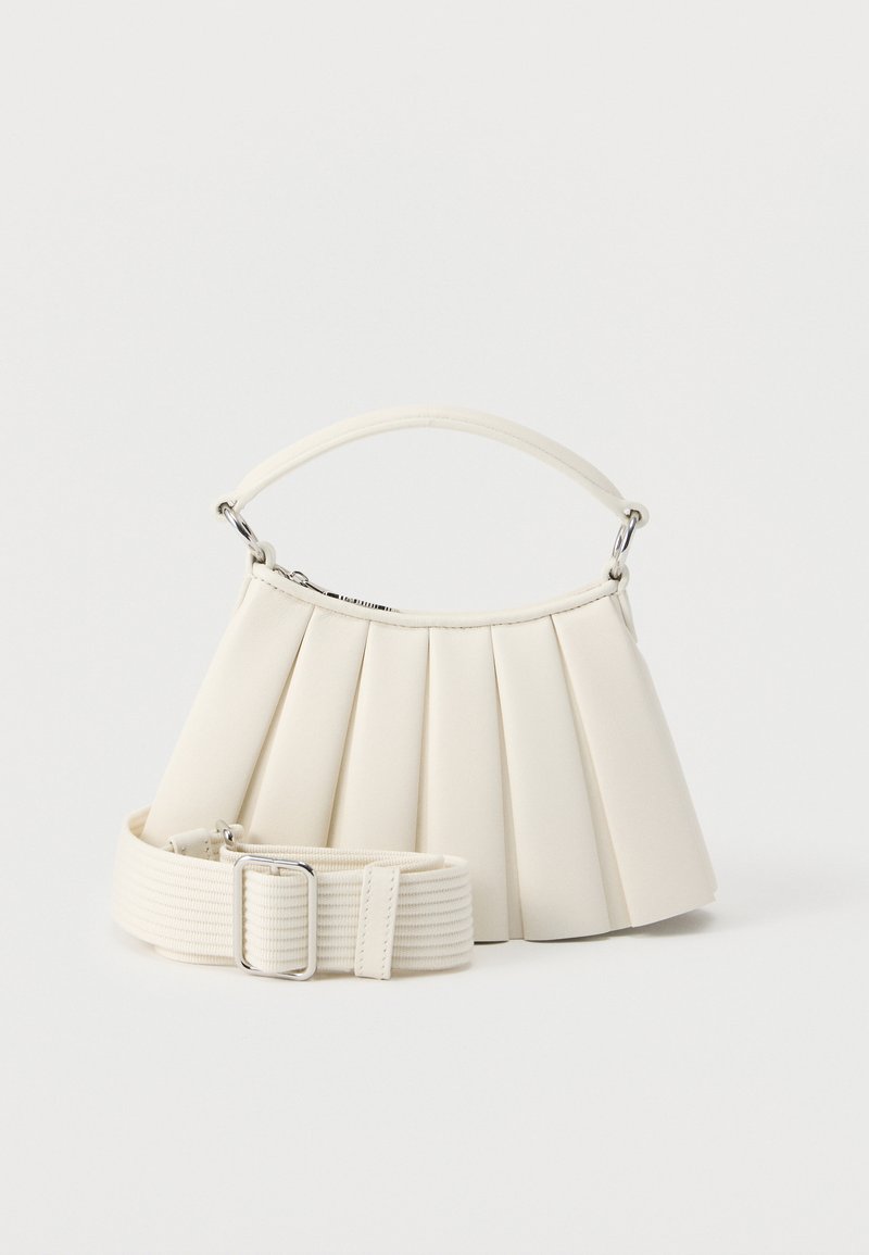 Λευκή τσάντα χειρός με πιέτες, κοντή λαβή και φαρδιά αποσπώμενη υφασμάτινη ράχη με ασημένια πόρπη.