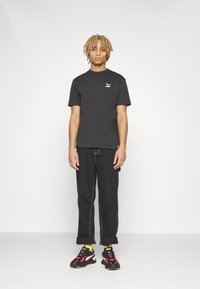 Puma PUMA STAPLE TEE - Apdrukāts T-krekls - puma black