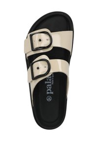 Beige gepatenteerde slipper met twee zwarte gespen, een zwarte textuurzool en een gevormde voetbed. "Made in Spain" gedrukt aan de binnenkant.