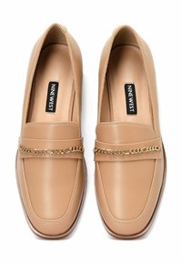 Šviesiai rudos odinės loafers tipo avalynės su kvadratu forma, auksine grandinėle ir siuvinėjimu. Lygus padas ir lengvai užmaunami dizainas patogiam dėvėjimui.