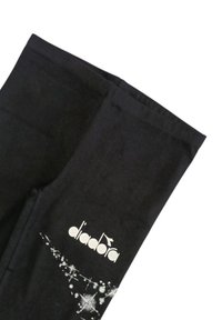 Tessuto nero con logo "diadora" bianco e design scintillante a stelle stampato sul materiale.