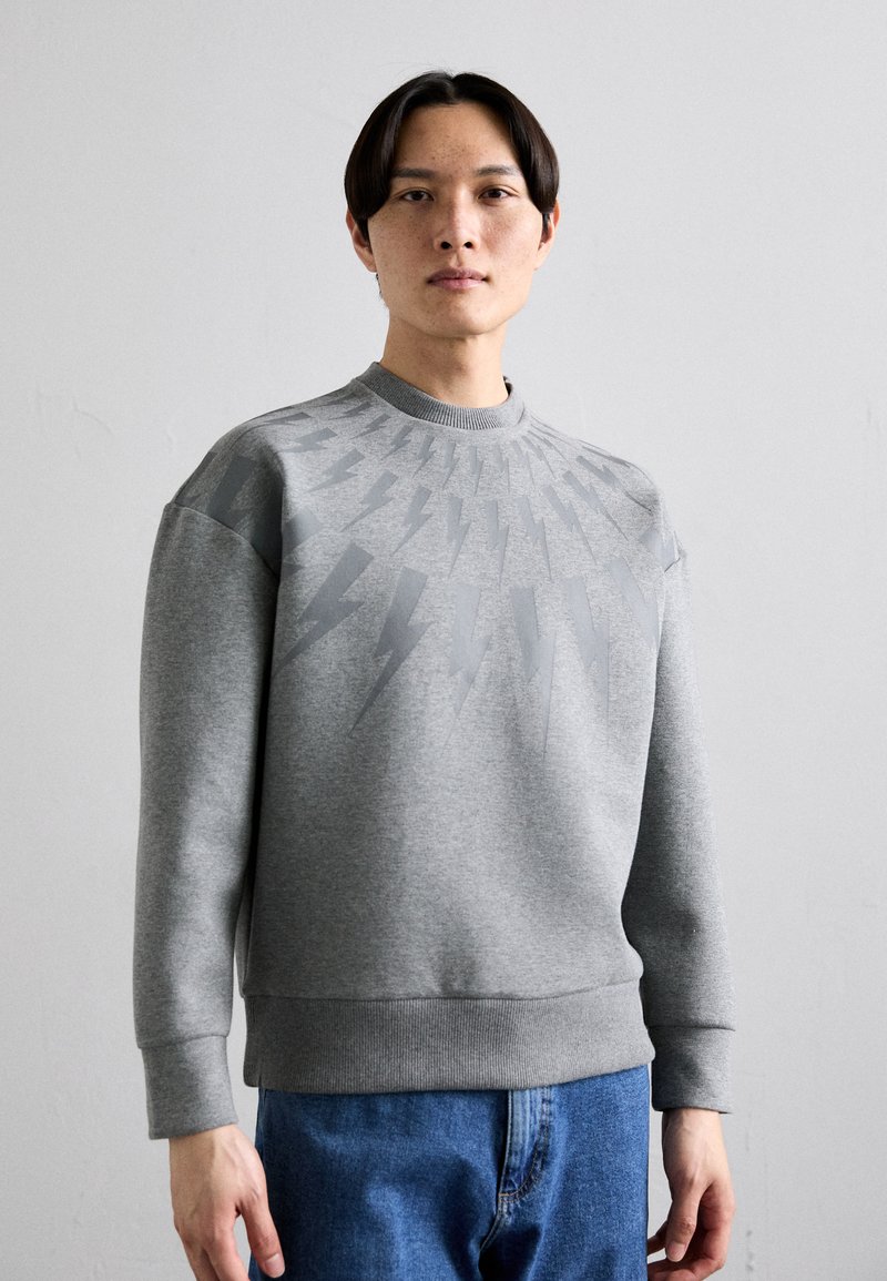 Grå sweatshirt med rund halsringning, prydd med ett radmönster av ljusgrå blixtar på bröstet samt ribbade ärmslut och fåll.