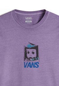 T-shirt di cotone viola con una grafica di un viso di bambola con un cervello blu e il testo "VANS" in grassetto blu, situato in basso.