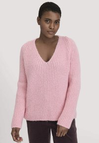 Hellrosa gestrickter Pullover mit V-Ausschnitt, geripptem Muster und langen Ärmeln. Weiches, gemütliches Material mit einer entspannten Passform.