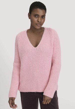 Pull en maille rose clair avec un col en V, texture côtelée et manches longues. Matière douce et confortable avec une coupe décontractée.