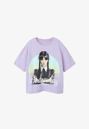 T-shirt lilas à manches courtes présentant un personnage illustré avec des tresses, une chemise à col et le mot "Mercredi" en gras.