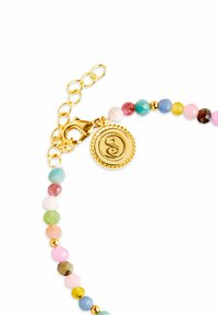 Pulsera de cuentas multicolores hecha de piedras semipreciosas pulidas, con un cierre de langosta en tono dorado y un charm circular con un remolino grabado.