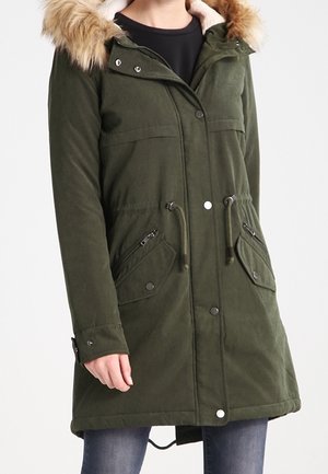 Olivgrüner Parka mit abnehmbarem Kunstfellkapuze, Druckknopf- und Reißverschluss, zwei großen schrägen Taschen und Kordelzug in der Taille.