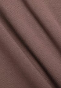 Tejido marrón acanalado con una textura suave, que muestra sutiles variaciones en color y profundidad a lo largo de pliegues diagonales.