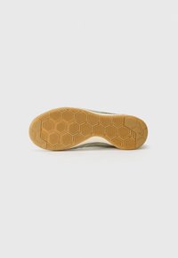 Sneaker sole in rubber with a honeycomb pattern; light gray upper with suede texture; minimalistic design; cream-colored accents.
