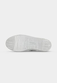 Semelle de chaussure en caoutchouc blanc avec des rainures horizontales texturées et le nom de la marque "Gabor" embossé au centre.