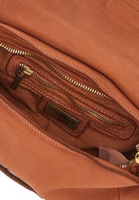 Interno di una borsa a tracolla in pelle marrone con una tasca con zip, texture liscia, hardware dorato e un'etichetta con il marchio "CATERINA LUCHI".