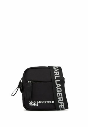 Petit sac bandoulière noir compact avec poche zippée à l’avant et large sangle de marque portant l’inscription Karl Lagerfeld en lettres blanches.