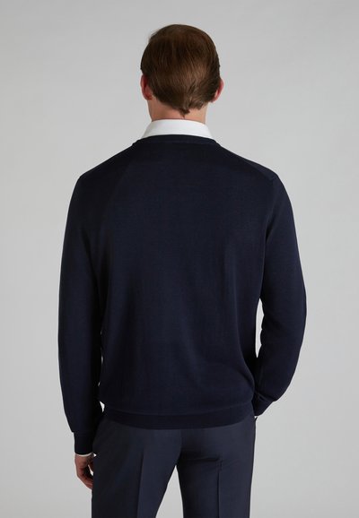 Navy blue knitted sweater with a crew neck, ribbed cuffs and hem, featuring a smooth texture and a clean, minimalist design.
