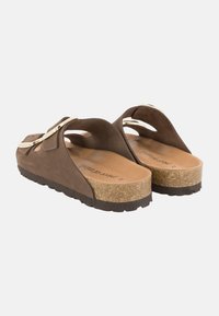 Sandales en suède marron avec bout rond, semelle en liège, semelle en caoutchouc et accents dorés. Design ouvert à l'arrière pour un enfilage facile.