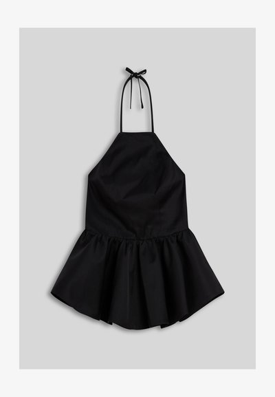 Robe noire sans manches à col licou avec un nœud au cou et une jupe évasée et froncée sur fond gris.