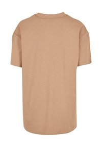 Tričko s krátkým rukávem ve světle béžové barvě z bavlny, s kulatým výstřihem, volným střihem a rovný lem bez dalších detailů.