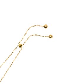 Złota bransoletka z łańcuszka z dwiema okrągłymi przekładkami na końcach. Posiada delikatny wzór ogniw i gładką, odbijającą światło powierzchnię.
