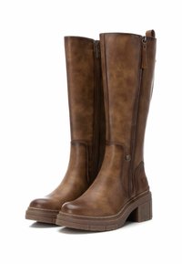 Botas marrones altas hechas de material sintético texturizado. Presentan un cierre lateral con cremallera y una suela gruesa y texturizada con un tacón modesto.