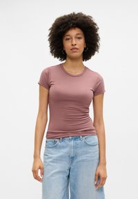 Lühikeste varrukatega, keha lähedalt liibuv t-särk mauve värvitoonis, valmistatud siledast puuvillakangast. Omab ümmargust kaelust ja kerget volti külgedel.