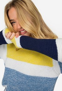 Färgglad, stickad tröja med horisontella ränder i marinblått, gult, vitt och ljusblått. Mjuk textur och rymlig passform med lång ärm.